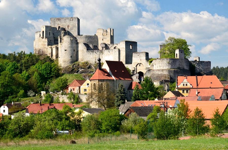 Zřícenina hradu Rabí nad vesnicí s červenými střechami